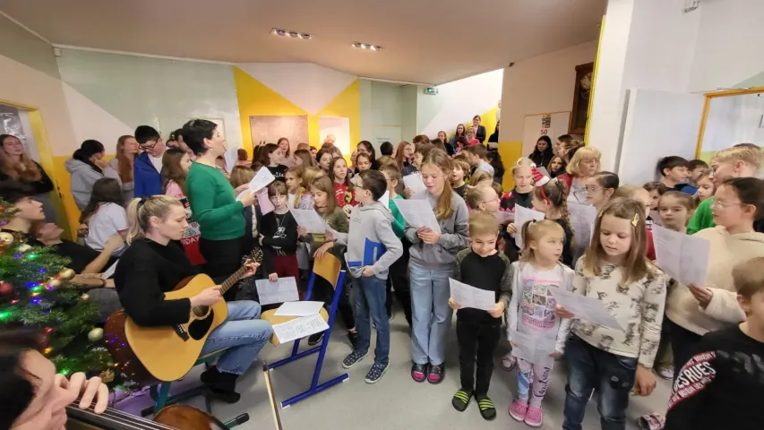 Vánoční zpívání u klavíru ve vestibulu školy